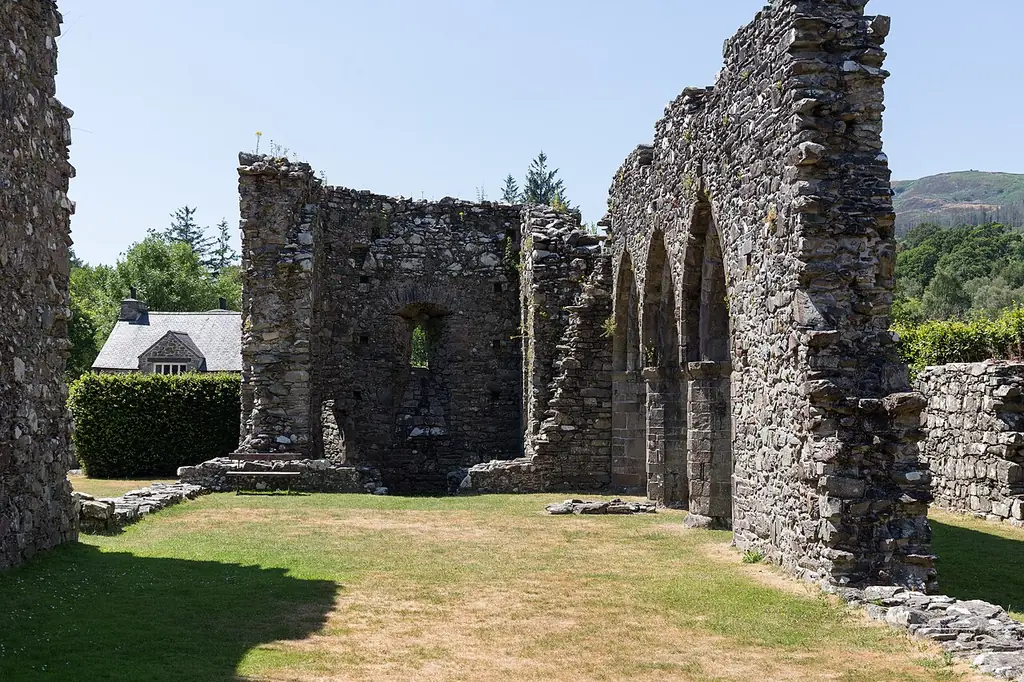The stone ruins and arched windows of Cymer Abbey in Llanelltyd
